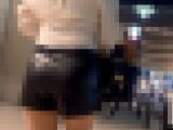 レザーショートパンツ姿で街を歩く美女